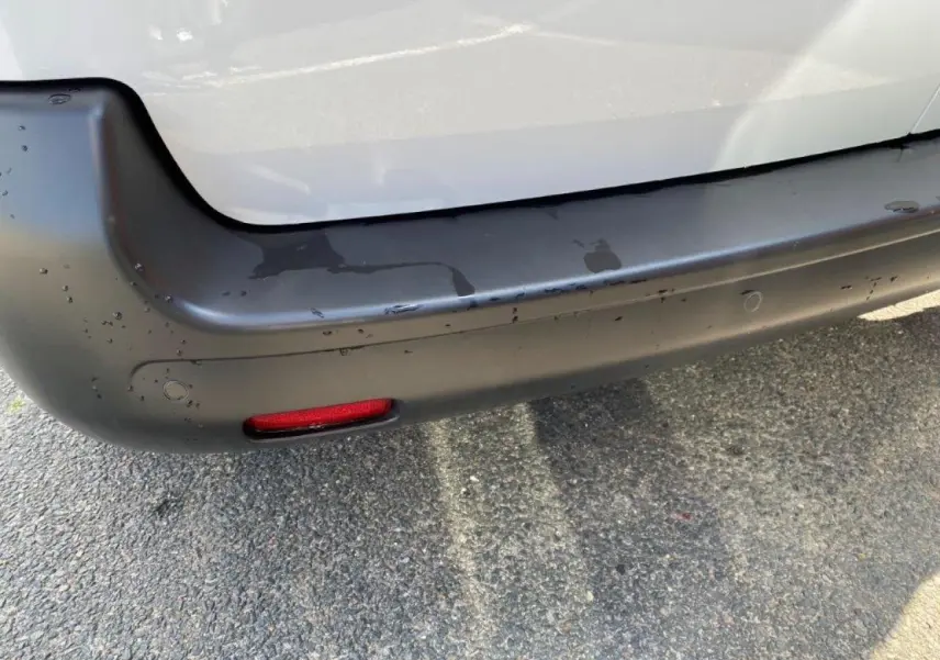 Gros plan sur le pare-chocs arrière noir et la carrosserie blanche du Peugeot Expert Fourgon 2023.