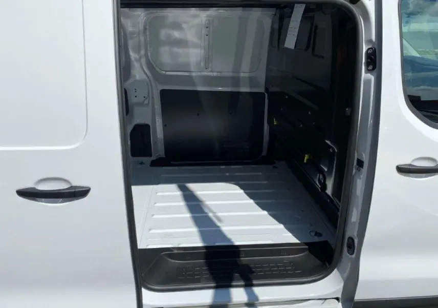 Vue intérieure du fourgon blanc Peugeot Expert Standard 2023, montrant l'espace de chargement côté droit avec porte coulissante ouverte.