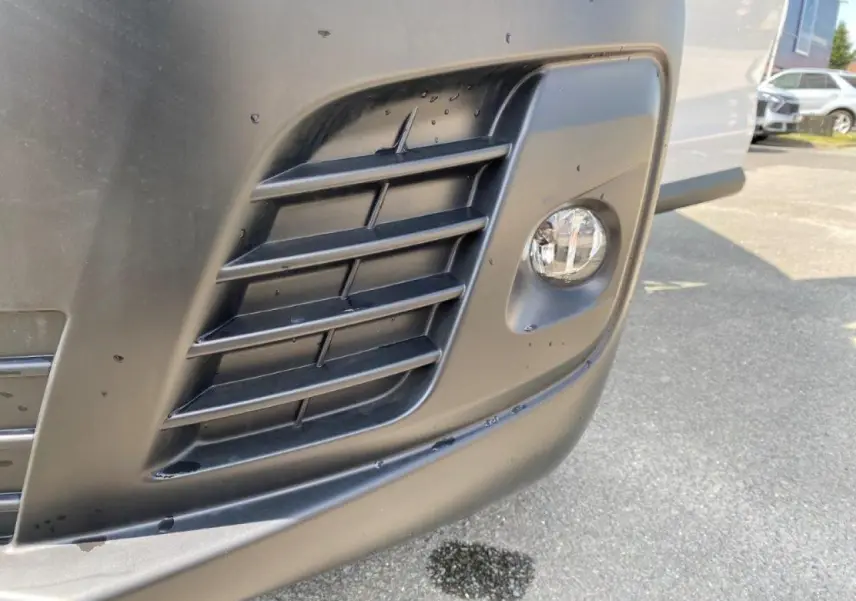 Gros plan sur le projecteur antibrouillard avant droit du Peugeot Expert Fourgon blanc 2023.