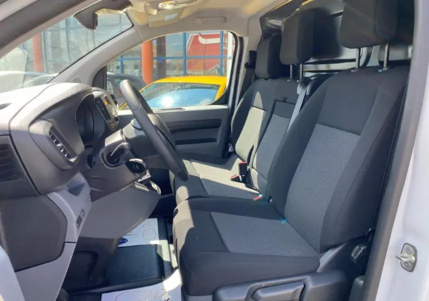 Intérieur du Peugeot Expert Fourgon blanc 2023, vue côté conducteur montrant la banquette passager Moduwork deux places.