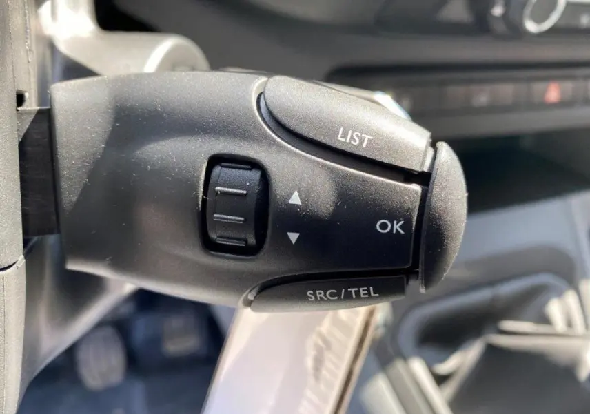 Gros plan sur la commande au volant du Peugeot Expert Fourgon blanc 2023, boutons LIST, OK et SRC/TEL visibles.