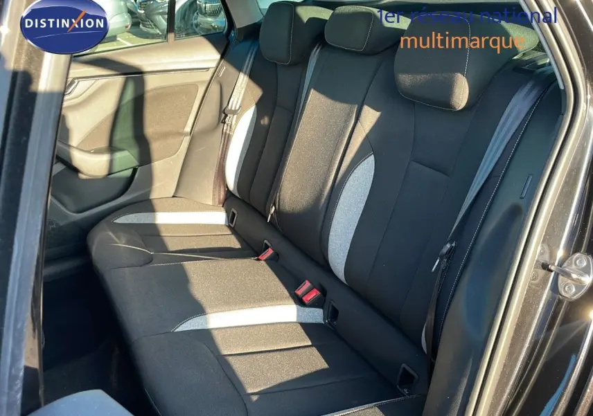 Vue intérieure côté arrière droit du Skoda Kamiq 2024 noir magique métal, montrant les sièges arrière en tissu gris et noir.