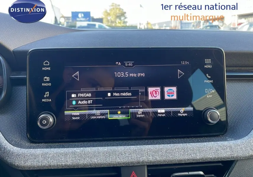 Écran tactile central du tableau de bord du Skoda Kamiq noir magique métal 2024, affichant la radio FM à 103.5 MHz.