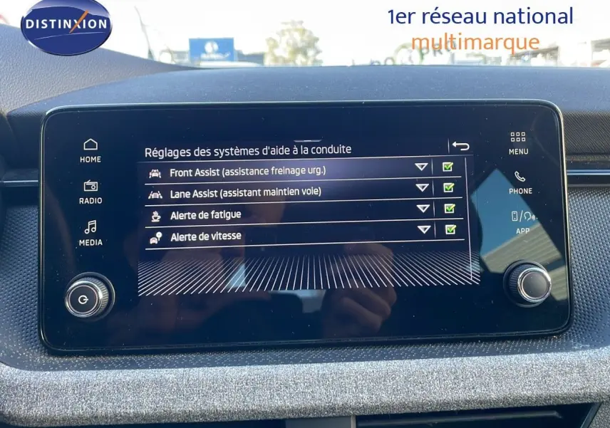 Écran tactile central affichant les réglages d'aide à la conduite du Skoda Kamiq noir magique métal, vue intérieure frontale.