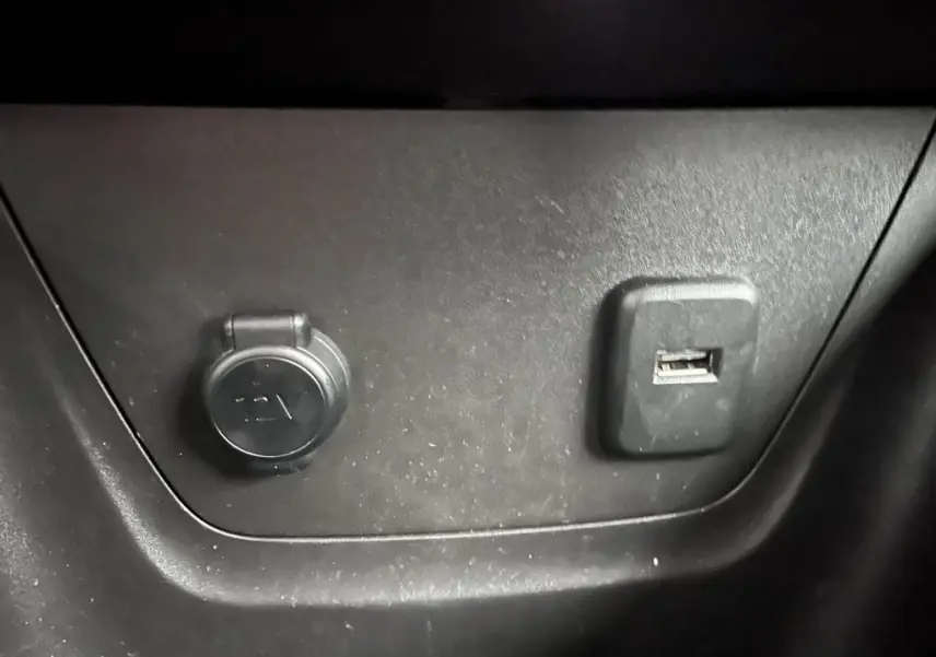 Prise 12V et port USB en gros plan sur la console intérieure d'une Opel Crossland bleu clair 2021.