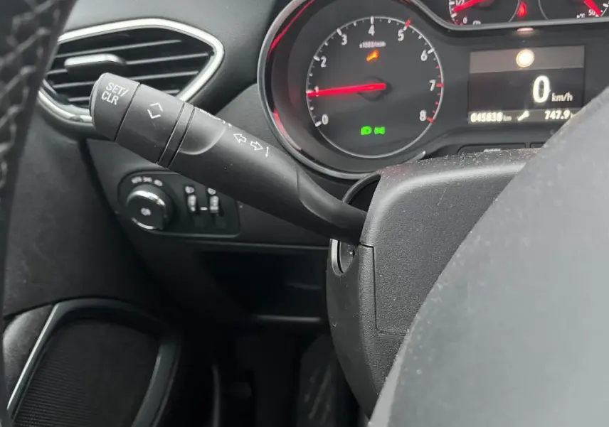 Gros plan sur la manette de clignotant à gauche du volant dans l'habitacle noir de l'Opel Crossland 2021.