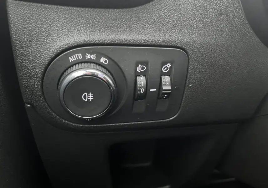 Gros plan sur les commandes d'éclairage noires du tableau de bord d'une Opel Crossland bleu clair 2021.