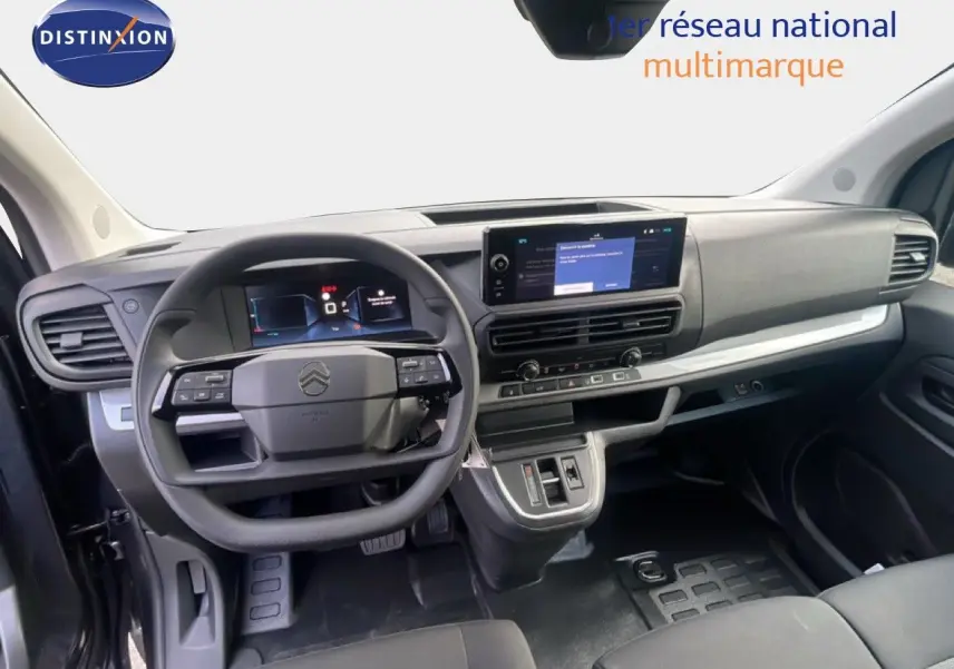 Vue intérieure du poste de conduite du Citroën Jumpy gris titane, avec tableau de bord numérique et écran central tactile.