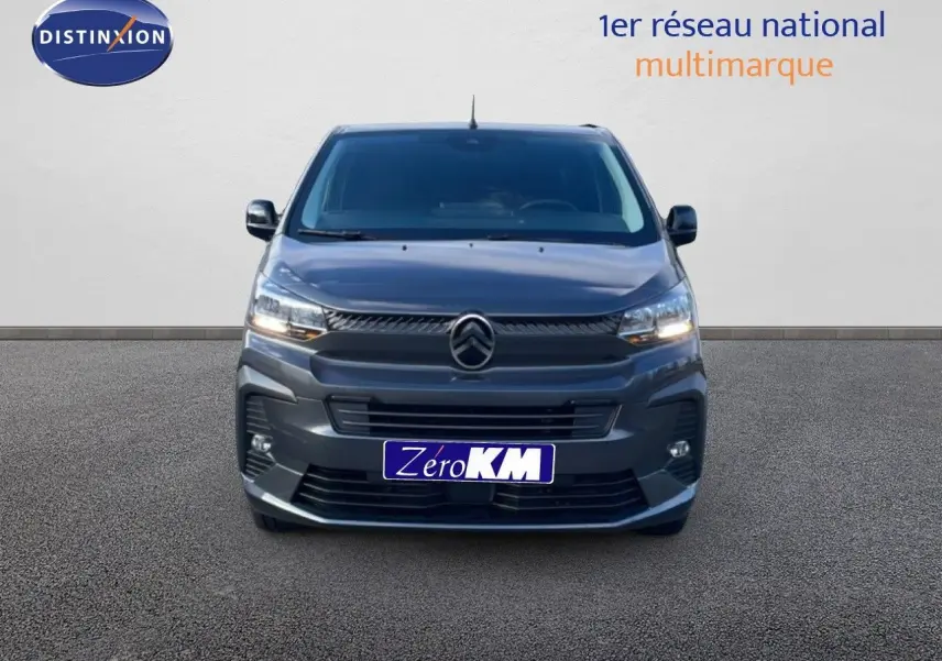 Vue frontale d'un Citroën Jumpy Van Long L3 gris titane métal avec phares allumés sur fond neutre.