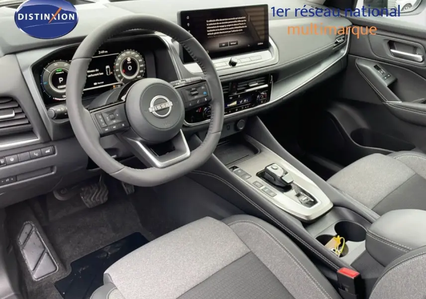Intérieur côté conducteur du Nissan Qashqai 2025 gris, vue sur tableau de bord et console centrale moderne.