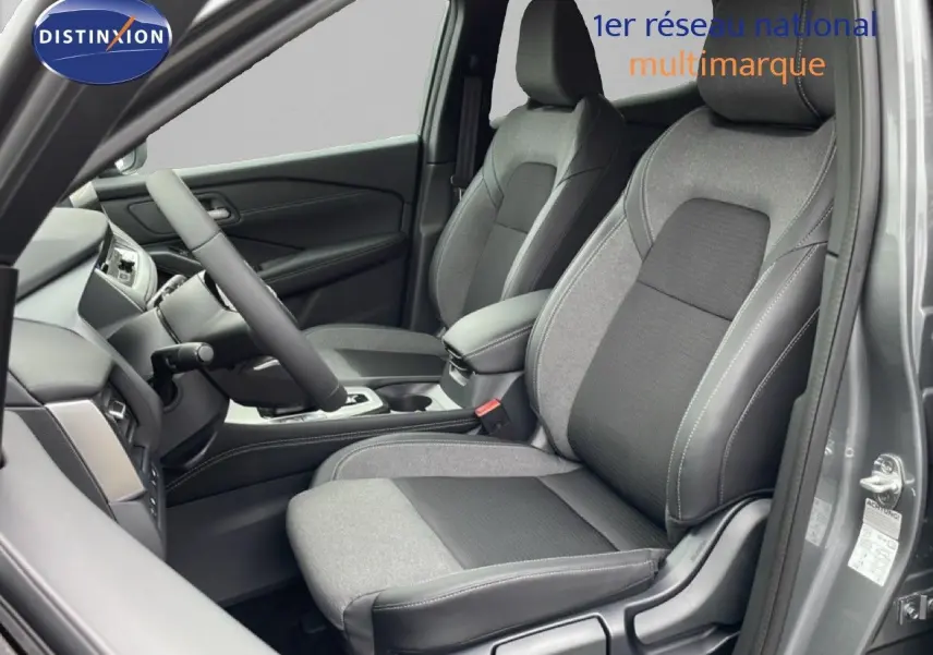 Vue intérieure côté conducteur du Nissan Qashqai 1.5 E-POWER 2025, sièges tissu gris et noir, tableau de bord moderne.