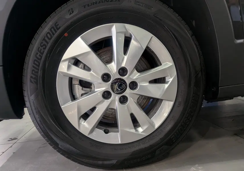 Gros plan sur la roue avant droite du Peugeot Rifter noir 2025, avec jante alliage argent et pneu Bridgestone Turanza.