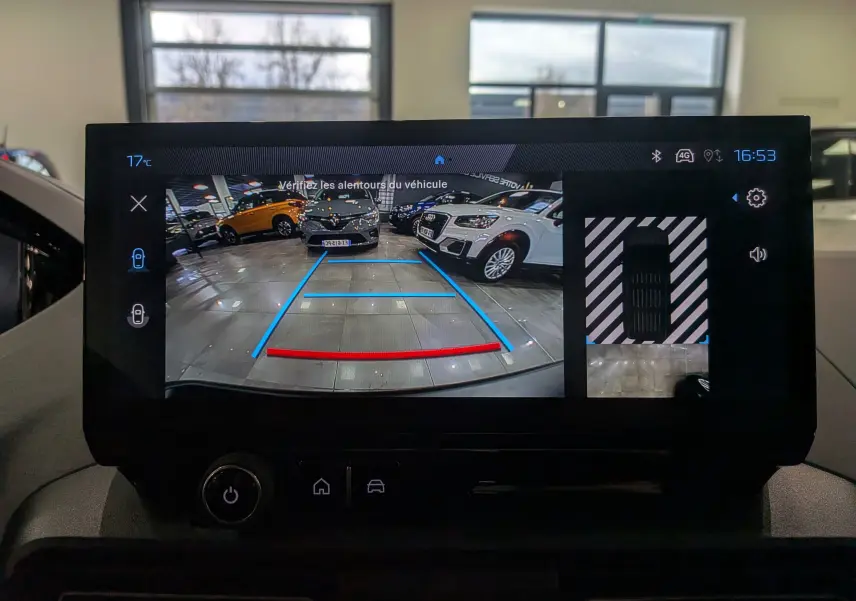 Écran de caméra de recul du Peugeot Rifter noir 2025, vue arrière avec repères de stationnement en bleu et rouge.