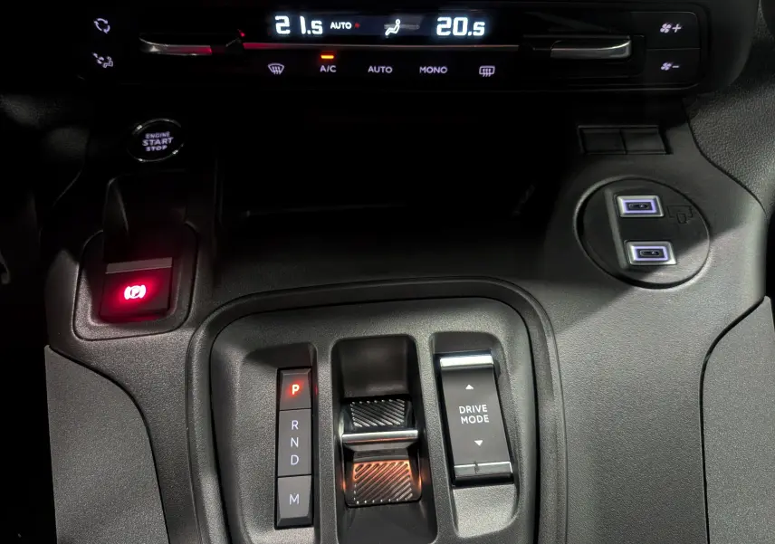 Gros plan sur la console centrale noire du Peugeot Rifter 2025, avec levier de vitesse automatique et commandes de mode de conduite.