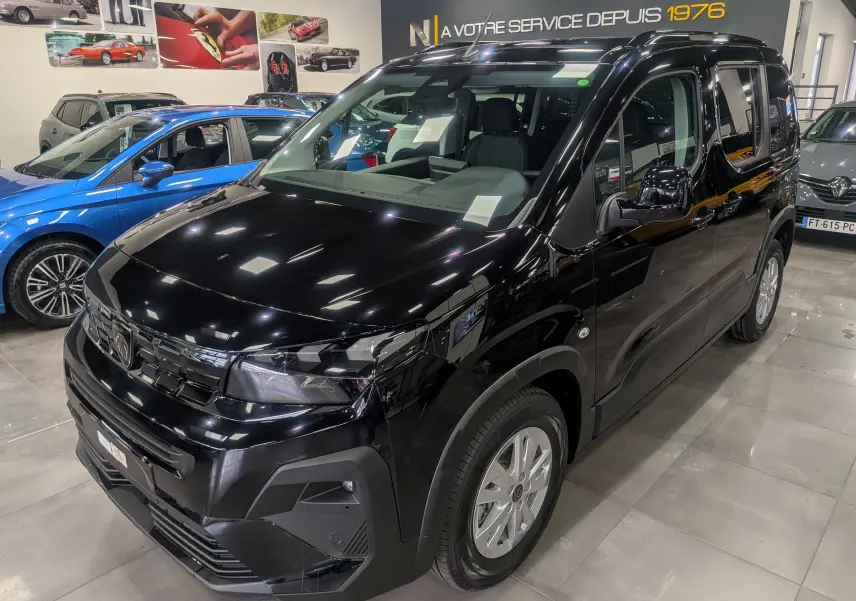 Vue 3/4 avant droite du Peugeot Rifter noir 2025 en showroom, avec calandre marquée et jantes argentées.