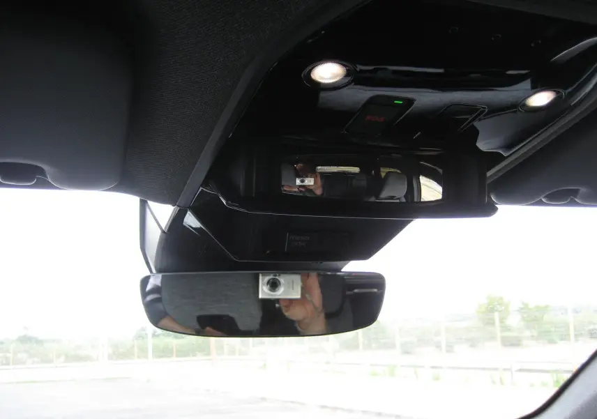 Vue intérieure centrée sur le rétroviseur et la console de plafond du Renault Austral gris, avec éclairage LED intégré.