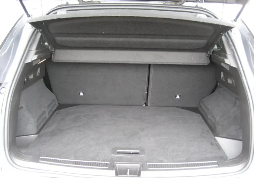 Coffre ouvert d’un Renault Austral gris, vue arrière montrant un espace de chargement spacieux et bien fini.