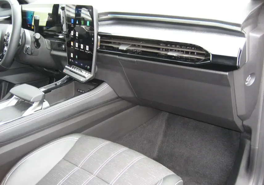 Vue intérieure côté passager du Renault Austral gris 2025, mettant en valeur la console centrale et l'écran tactile vertical.