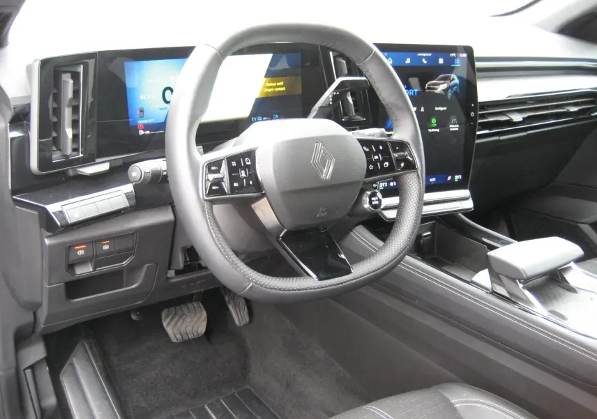 Vue intérieure du tableau de bord et volant du Renault Austral 2025, avec écran tactile et finitions noires modernes.