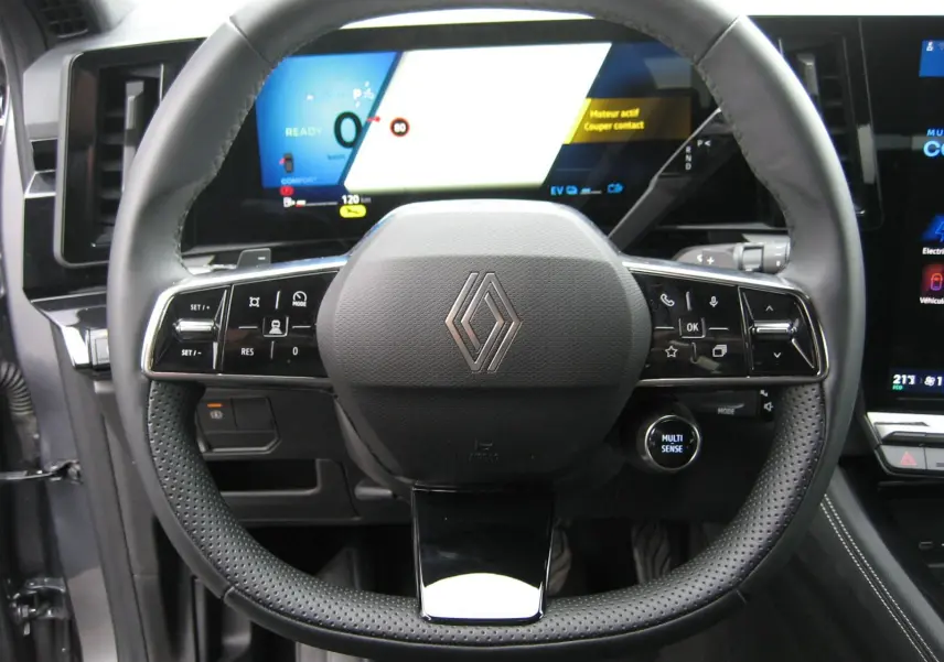 Vue rapprochée du volant en cuir noir du Renault Austral 2025 avec commandes intégrées et tableau de bord numérique.