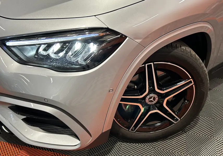 Gros plan sur l'avant droit d'un Mercedes GLA 200 D AMG Line 2024 argent High-tech avec jante AMG noire à 5 branches.