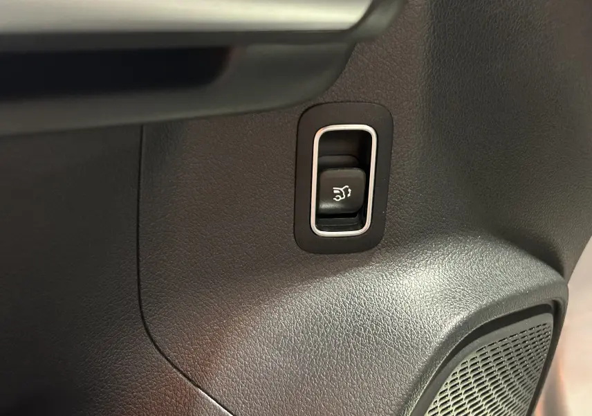 Bouton d'ouverture électrique du hayon sur panneau intérieur noir du Mercedes GLA 200 D AMG Line 2024 argent High-tech.