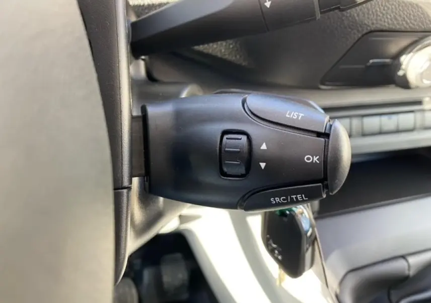 Gros plan sur la commande au volant noir du Peugeot Expert Fourgon blanc banquise, avec clé insérée dans le contact.