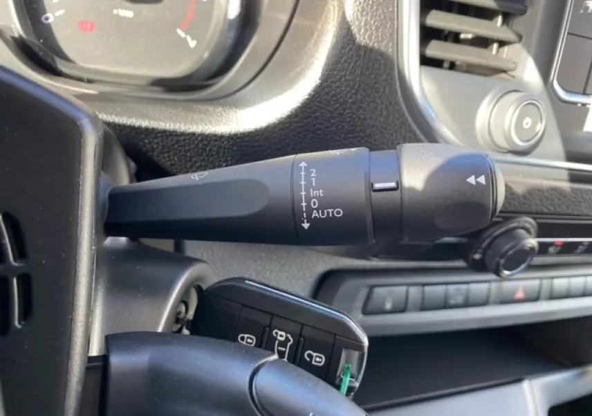 Gros plan sur la commande d'essuie-glace et la clé HF du Peugeot Expert Fourgon blanc banquise, tableau de bord en arrière-plan.