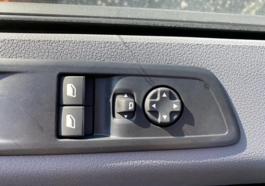 Gros plan sur les commandes des vitres et rétroviseurs côté conducteur du Peugeot Expert Fourgon blanc banquise 2023.