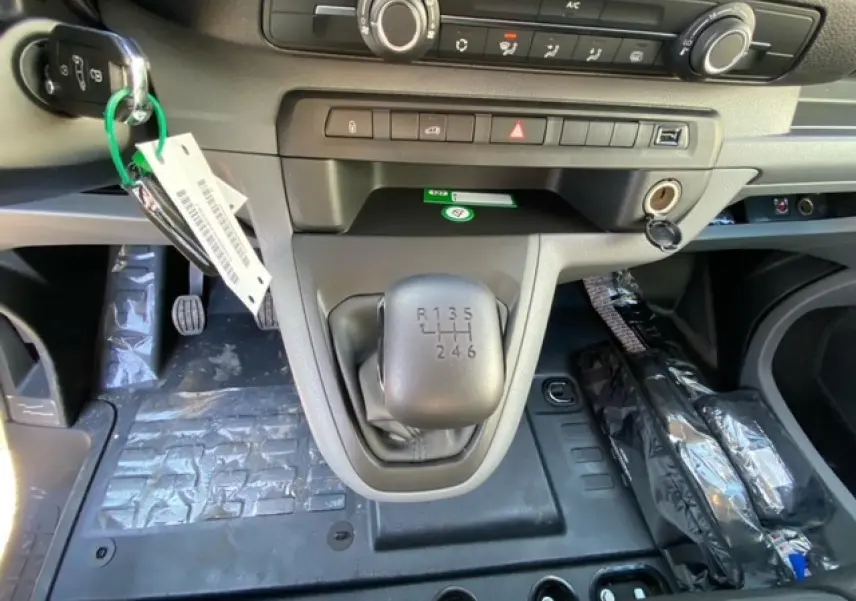 Gros plan sur la console centrale du Peugeot Expert Fourgon blanc banquise 2023, mettant en valeur le levier de vitesse manuel à 6 rapports.