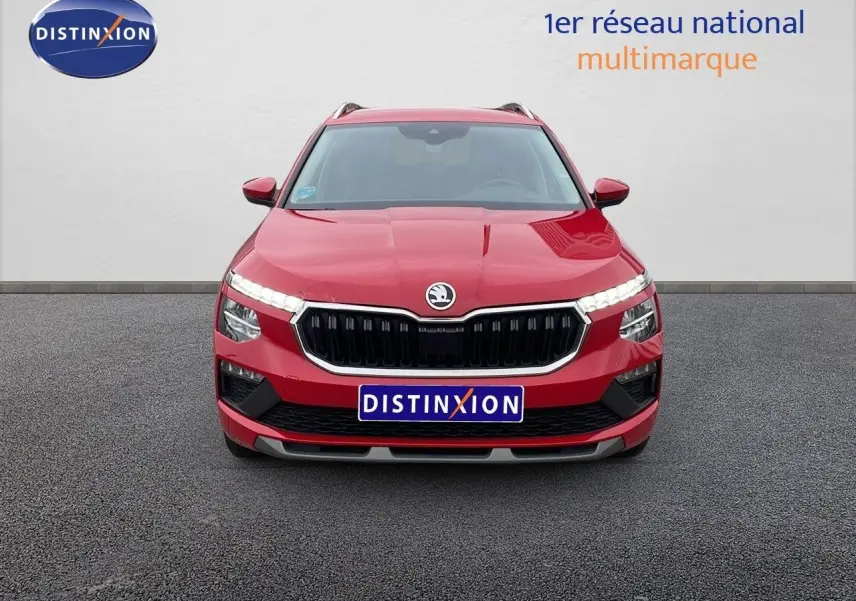 Vue frontale d'un Skoda Kamiq rouge Velvet Metal avec calandre noire et feux LED allumés sur fond neutre.