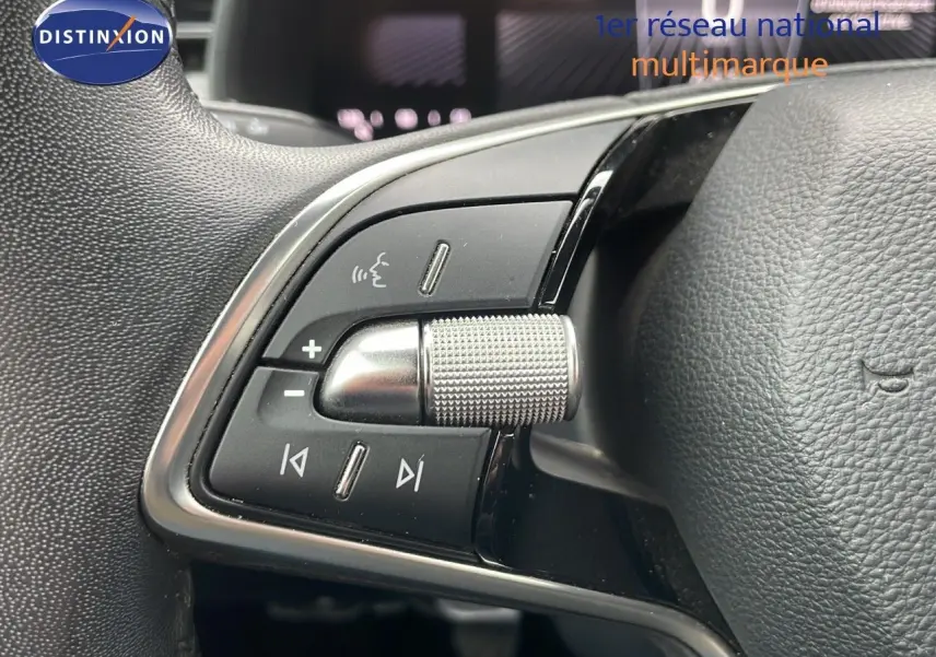 Gros plan sur les commandes gauche du volant en cuir noir du Skoda Kamiq 2024 rouge Velvet Metal.