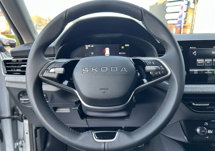 Vue rapprochée du volant cuir noir du Skoda Kamiq 2025 avec tableau de bord digital et écran central tactile.