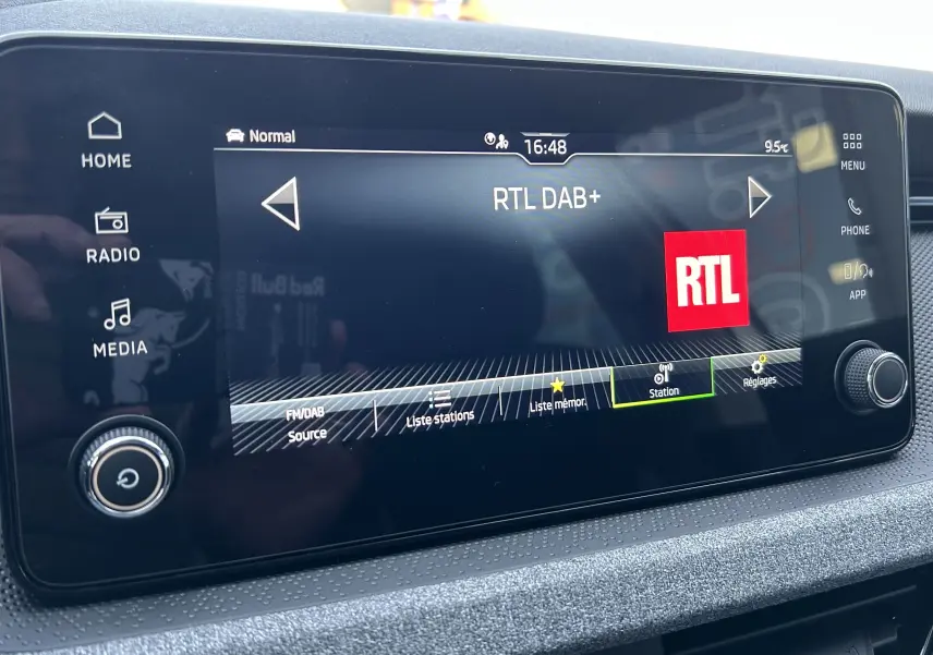 Écran tactile central du Skoda Kamiq 2025 gris argent, affichant la radio RTL DAB+ avec commandes tactiles et molette.