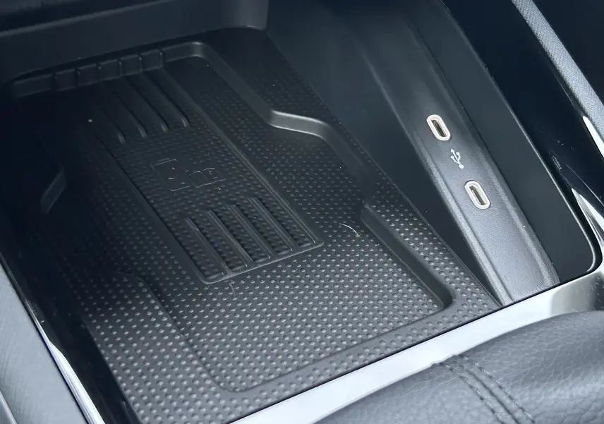 Gros plan sur le chargeur à induction et ports USB-C du Skoda Kamiq gris argent 2025, intérieur noir.