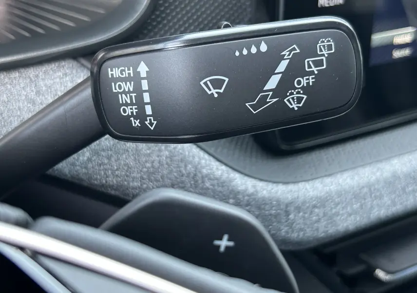 Gros plan sur la manette d’essuie-glace noire dans l’habitacle gris foncé du Skoda Kamiq 2025 gris argent métal.