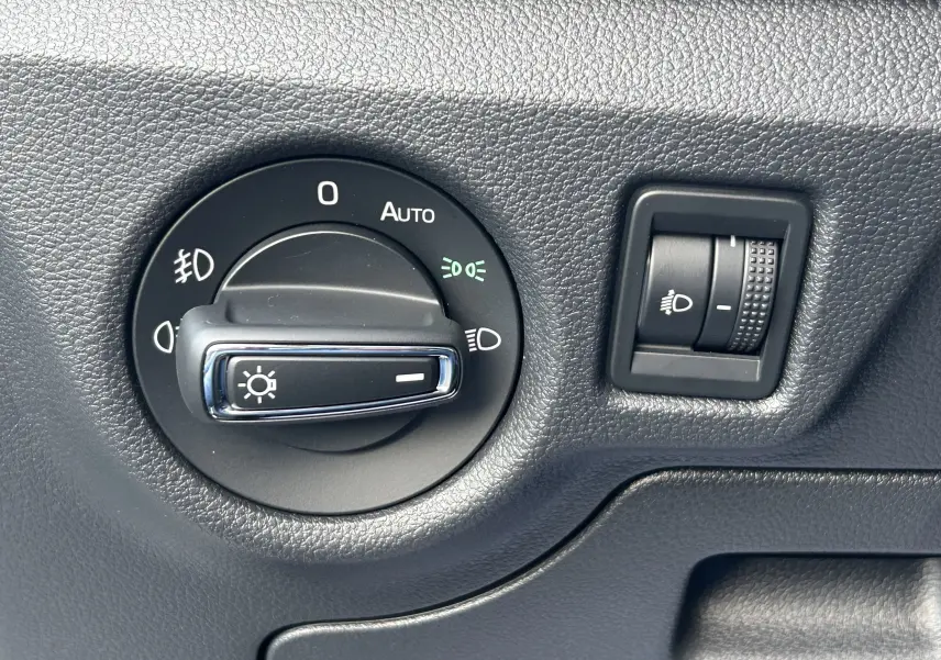 Gros plan sur les commandes d’éclairage intérieures noires du Skoda Kamiq 2025, avec réglage automatique activé.