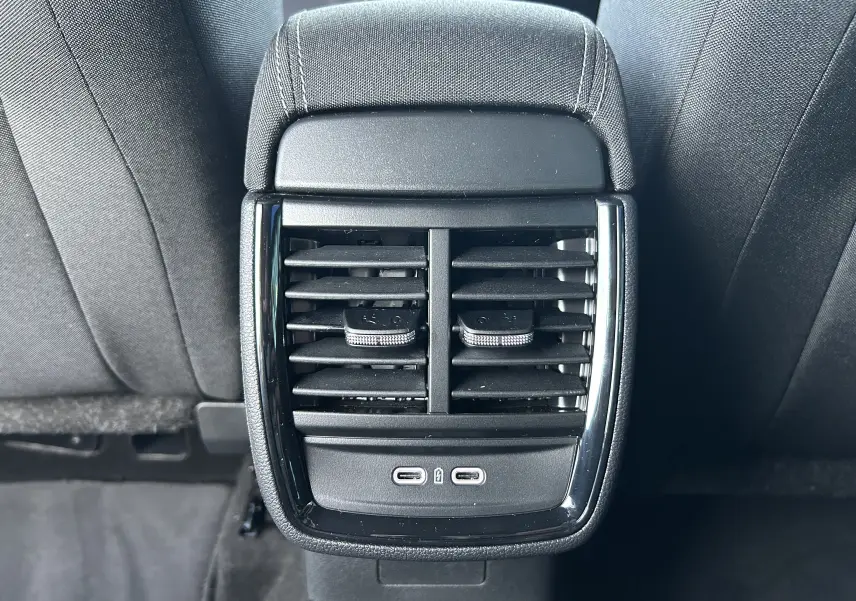 Vue rapprochée des aérateurs arrière noirs et ports USB-C du Skoda Kamiq gris argent 2025, entre les sièges arrière.