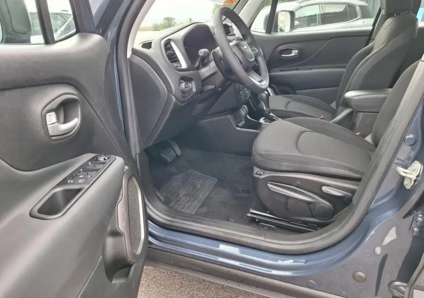 Vue intérieure côté conducteur du Jeep Renegade bleu 2024, montrant siège, volant et tableau de bord.