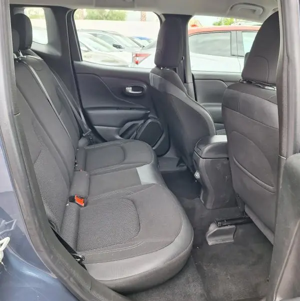 Vue latérale intérieure arrière du Jeep Renegade bleu 2024, montrant les sièges en tissu noir et l'espace passager.