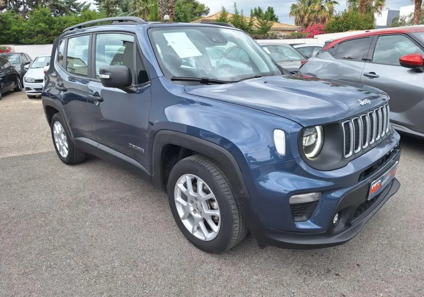 Jeep Renegade bleu vue 3/4 avant droit, avec barres de toit et jantes alliage 17 pouces visibles en extérieur.