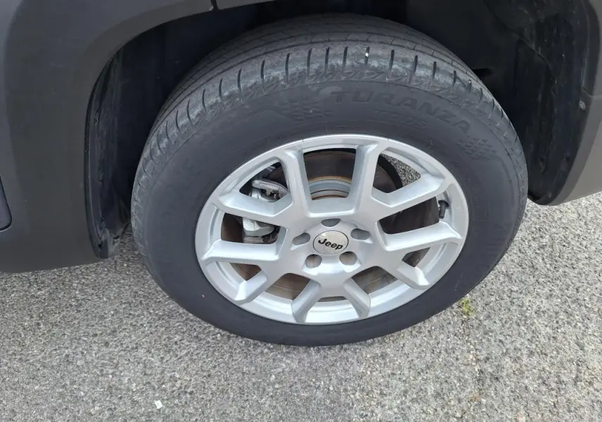 Gros plan sur la roue avant droite avec jante alliage 17 pouces du Jeep Renegade bleu 2024.