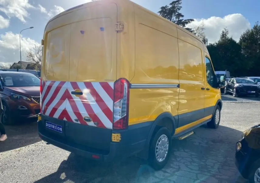 Ford Transit Fourgon orange vu en 3/4 arrière droit avec marquage rouge et blanc sur portes arrière tôlées.