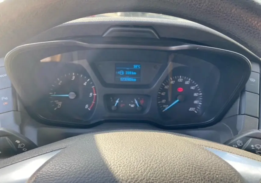 Vue rapprochée du tableau de bord du Ford Transit Fourgon orange 2015, affichant compteurs et écran digital.