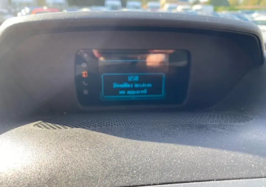 Écran central du tableau de bord du Ford Transit Fourgon orange 2015 affichant un message USB, vue intérieure rapprochée.