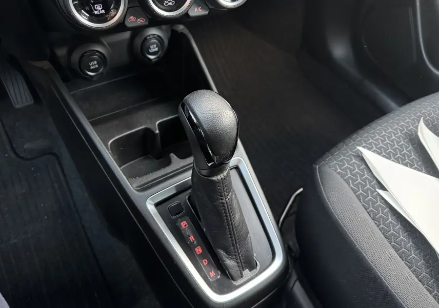 Le levier de vitesses automatique en cuir noir de la Suzuki Swift 1.2 Pack Auto 2023, vue intérieure centrée.