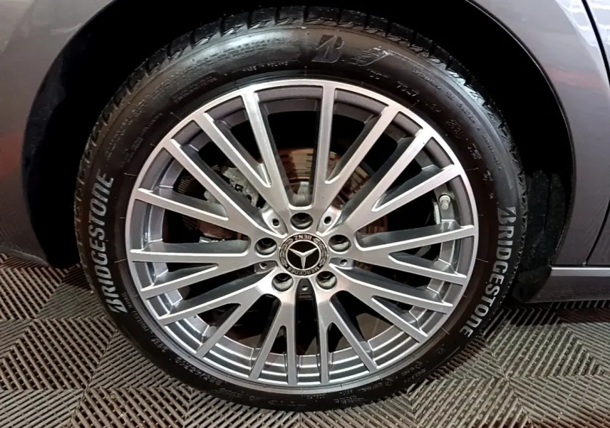 Gros plan sur la roue avant droite d'une Mercedes CLA 180 d Business Line gris clair avec jante alliage multi-branches.