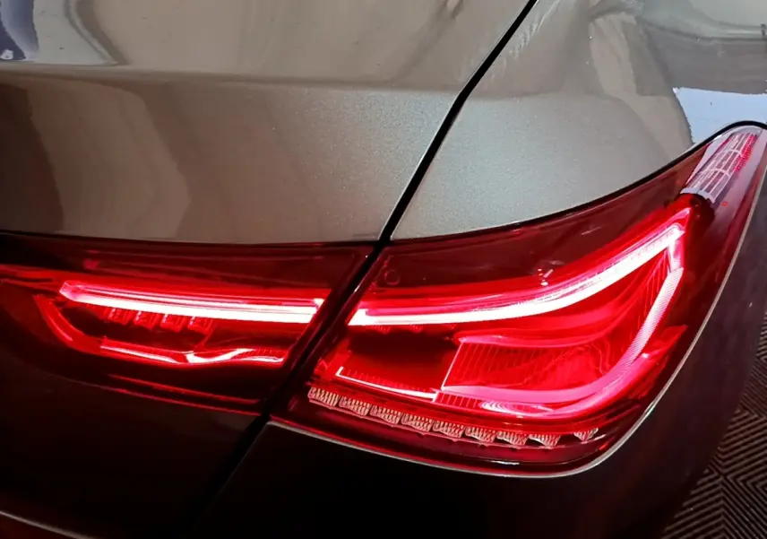 Gros plan sur le feu arrière droit rouge d'une Mercedes CLA 180 d Business Line gris clair 2021.