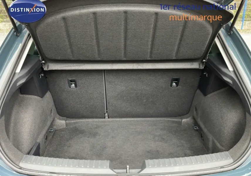 Coffre ouvert vu de l'arrière d'une SEAT LEON gris magnétique métal, montrant un espace de chargement propre et spacieux.