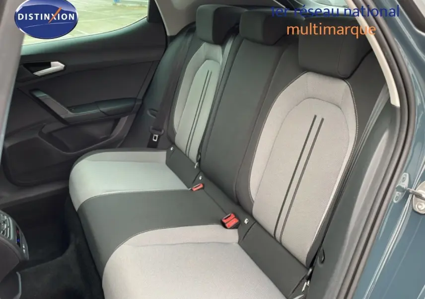 Vue intérieure côté arrière droit montrant la banquette bicolore gris clair et noir du SEAT LEON 2025 gris magnétique métal.